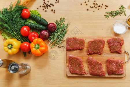 将新鲜牛肉羊肉或猪里脊肉放在木桌上的切菜板上图片