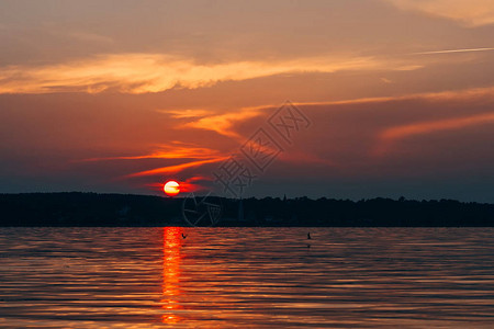 在水面上日落红太阳和橙色天空图片