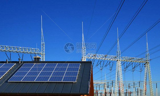 背景高压变电站房屋顶上的太阳能电池板图片