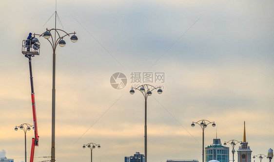 城市冬季晚上修补街道灯的电动人员图片