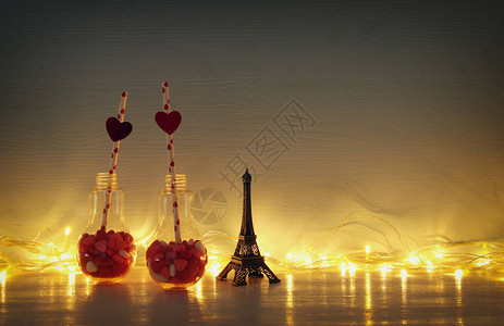 情人节的浪漫背景有塑料灯泡心型甜糖盘在桌子上图片