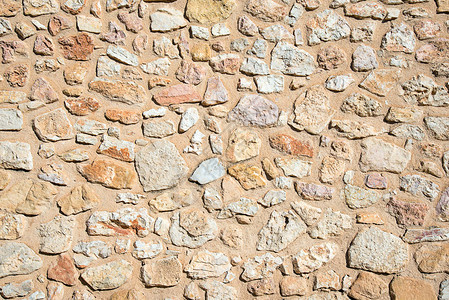 从天然石材制成的粗糙墙壁的背景背景图片