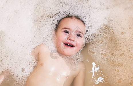 快乐的小女孩在浴室里游泳图片