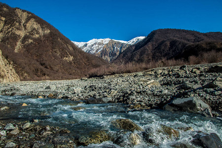 溪流河山风景摄影远处的雪峰图片