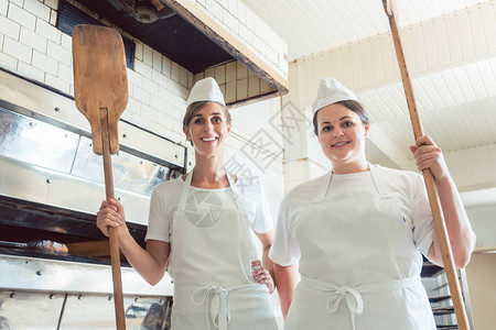 面包师团队的女面包师队在面包店骄傲地站背景图片