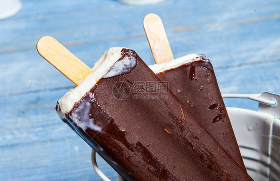 巧克力冰淇淋在蓝色的木制背景上弹出生锈的背景上的巧克力冰淇淋爱斯图片