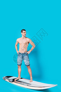骑着冲浪板的健壮男子手握腰部图片