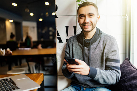 繁荣的男企业家在咖啡馆工作的智能手机上发送消息图片