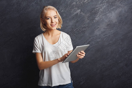 幸福的女人在灰色的背景上使用数字平板电脑通信和技术概图片