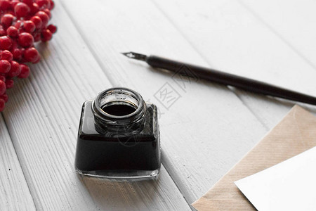 白色木桌上的一套老式蘸笔墨水瓶带信封和红图片
