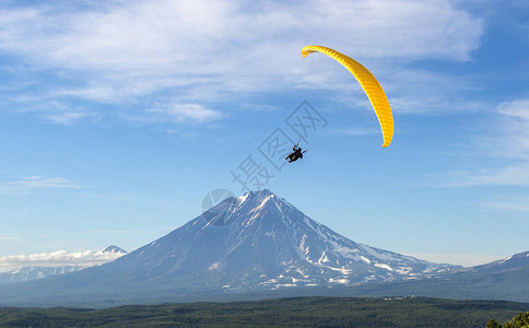 滑翔伞在蓝天白云的映衬下飞翔图片