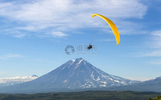 滑翔伞在蓝天白云的映衬下飞翔图片