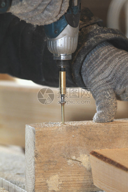 木匠手的特写用螺丝刀在木板上拧螺丝工图片