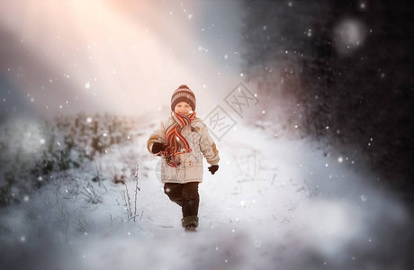 快乐的小男孩在雪中玩耍冬天风景图片