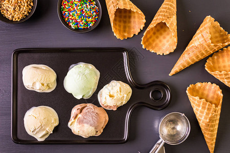 华夫饼冰淇淋锥和盘子的冰淇淋勺图片