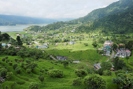 山湖附近的一个绿色山谷中的小镇图片