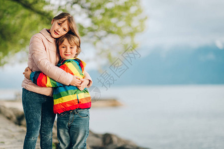 两个小孩在寒冷的日内瓦湖边玩耍图片