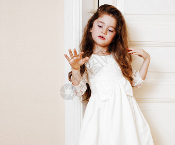 家里可爱的小女孩穿着白衣服在门近处穿得漂图片
