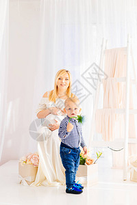 一位身着白裙子的孕妇坐在椅子上背景图片