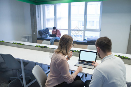 一个男人和一个女孩作为一个团队在工作空间的电脑前工作讨论工作流程在联图片