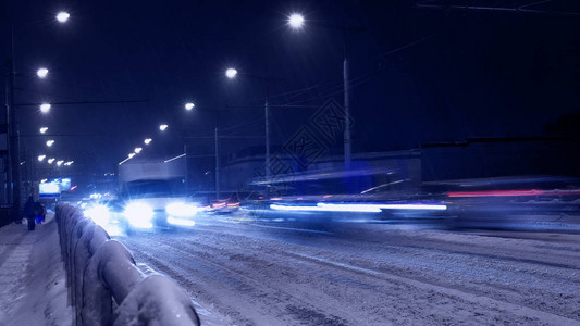 蓝色降雪中夜间汽车交通模糊图片