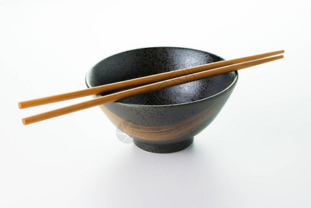 日本空碗白色背景上隔着一双筷子图片