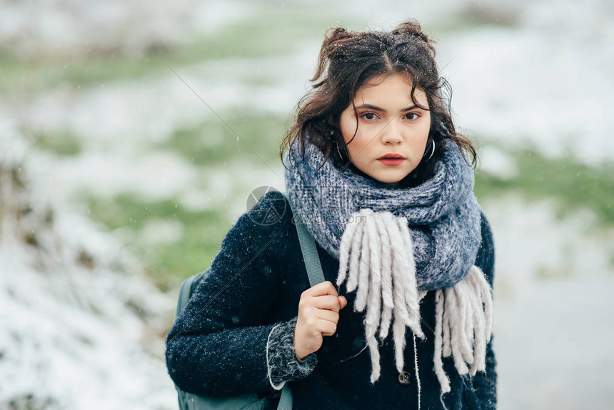 寒冷的季节一个穿着温暖衣服的漂亮女孩在背包图片