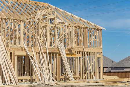 美国得克萨斯州欧文市竣工房屋旁边正在建造的特写木结构房屋图片