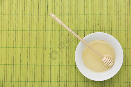 绿色竹桌上的蜂蜜图片