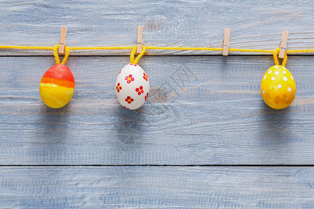 彩色花环与木背景上的彩绘鸡蛋质朴的桌面视图上色彩缤纷的假日装图片