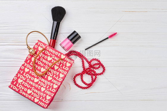 美容饰品成分木制背景红色礼品袋和女美容图片