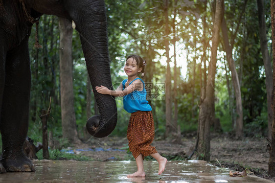 亚洲女孩在雨中玩大象图片