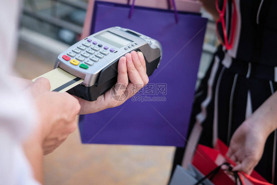 女人用信卡刷通过终端付款客户使用EDC或刷卡机付款买图片