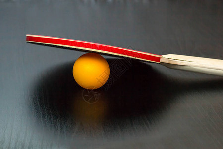 乒乓球或乒乓球拍和黑色背景上的球图片