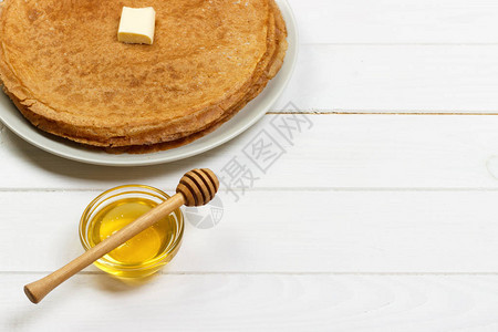白木桌上有蜂蜜的炸饼上图片