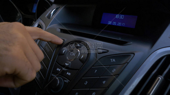 芒手将磁盘放入汽车播放器汽车中光盘播放器的按钮控制手将磁盘放入收音图片