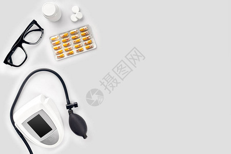 用于测量血压胶囊中的平板和白桌上的眼镜的电子医疗计时器顶部视图静态生图片