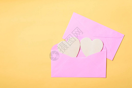 粉红色信封内有白色心橙色背景图片