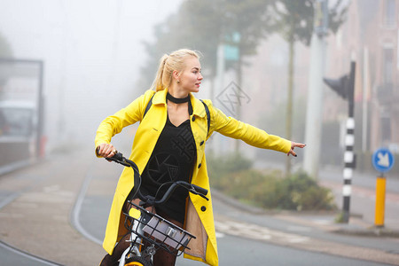 在迷雾城市骑自行车穿着黄外套的图片