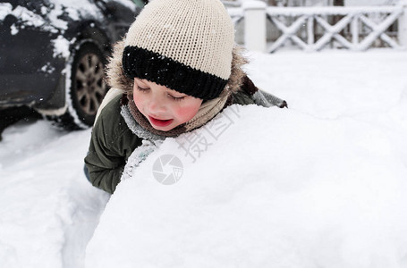 美丽的孩子在花园里造雪人图片