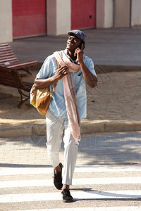 英俊的非洲男子在城市外通过电话交谈的全背景图片