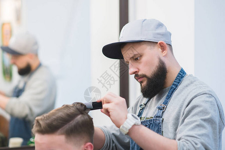 一个有胡子的时髦理发师长着剪刀制造了男发型在理发图片