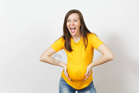 欧洲年轻快乐的女人足球迷或足球运动员在黄色制服下怀孕图片