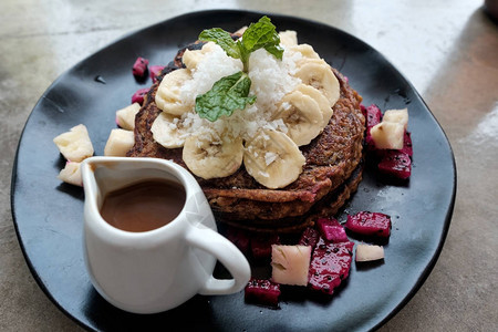 配有香蕉和巧克力早餐来源的Vegan棕色煎饼图片