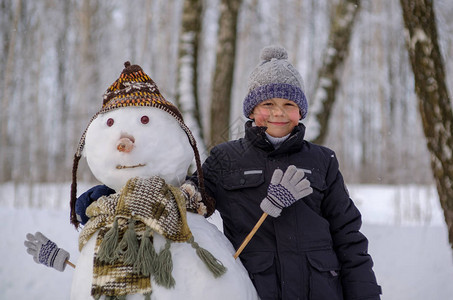 冬日雪地里可爱的欧洲男孩和雪地树林图片