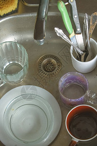 在水槽中泡沫中的脏盘子等待洗涤床板图片