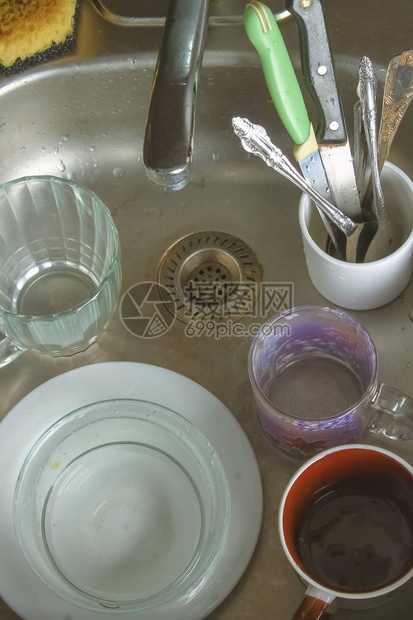 在水槽中泡沫中的脏盘子等待洗涤床板图片