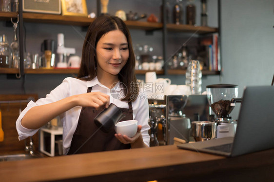 咖啡师女人在咖啡店柜台后面准备煮意式浓缩咖啡图片