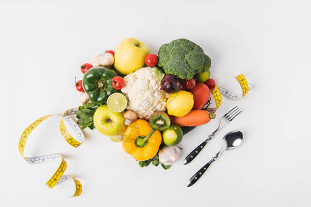 蔬菜和水果用叉子勺子和测量胶带铺图片