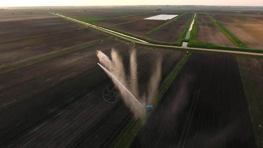 灌溉设备浇灌新鲜播种的田地灌溉农田以确保作物的质量鸟瞰图图片